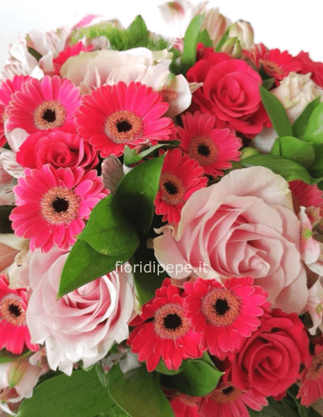 Composizione di fiori freschi assortiti, in particolare gerbere e rose.